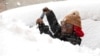 Zaria Black, 24, , clears off her car as snow falls in Buffalo, N.Y. 