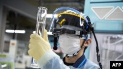 2022年3月5日，在日本大隈，东京电力公司福岛第一核电站的一名员工对污水样本进行氚测量。