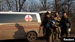 Mjekët ukrainas sjellin një ushtarak të plagosur në spitalin fushor (25 dhjetor 2022)