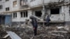 Members of the Demining Unit of the State Emergency Service inspect the area around a heavily damaged apartment block, following an artillery attack in Kharkiv, Ukraine, April 13, 2022. 
