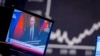 FILE - Russia's President Vladimir Putin appears on a television screen at the stock market in Frankfurt, Germany, Feb. 25, 2022.