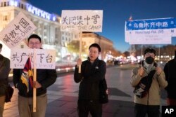 在美国首都华盛顿白宫附近举行抗议的人群手举要求共产党下台的标语。（2022年12月4日）