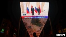 在乌兹别克斯坦举行的上海合作组织峰会期间，在中国北京的一块巨大显示屏正在播放中国国家主席习近平和俄罗斯总统普京的合影留念。(2022年9月16日)