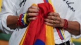 Una mujer sostiene una bandera venezolana durante una conferencia de prensa de activistas para denunciar el fin de las protecciones a cientos de miles de venezolanos de la deportación, el lunes 3 de febrero de 2025, en Doral, Florida, Estados Unidos.