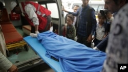 Yemenis carry the body of a girl who was killed in an explosion, at a hospital in Sanaa, Yemen, April 7, 2019. 