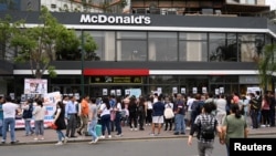 Familiares de las víctimas y ciudadanos peruanos protestan frente a un McDonalds por la muerte de dos jóvenes que fueron electrocutados por una máquina defectuosa de gaseosas. Reuters/Guadalupe Pardo.