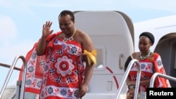 King of Swaziland Mswati III (Front) and one of his 13 wives disembark from a plane after arriving at Katunayake International airport in Colombo, Sri Lanka, August 13, 2012.