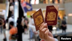 一名香港示威者在反对港版国安法的抗议中手举英国国民海外护照。（2020年6月1日）