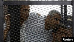 FILE - From left, Peter Greste, Mohamed Fahmy and Baher Mohamed listen to the ruling at a court in Cairo, Egypt.