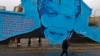 FILE - A woman walks past a mural with the face of former South African President Nelson Mandela in Cape Town, South Africa, July 18, 2014. 