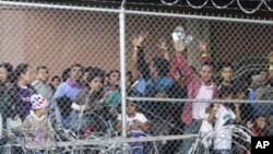 Migrantes centroamericanos esperan comida en un corral erigido por la Aduana y Protección Fronteriza de EE.UU. para procesar un aumento de familias migrantes y menores no acompañados en El Paso, Texas