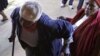 FILE - An elderly voter struggles into a polling station in Soweto, South Africa, May 2011.