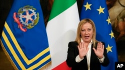 New Premier Giorgia Meloni gestures during the handover ceremony with outgoing Premier Mario Draghi at Chigi Palace Premier's office, in Rome, Sunday, Oct. 23, 2022. 