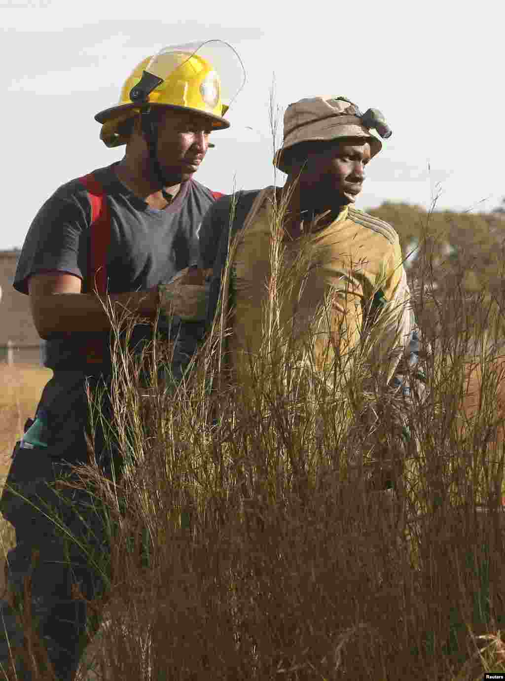 South African rescuers started bringing to the surface at least 30 illegal miners who had been trapped by debris in the abandoned gold shaft near Johannesburg, South Africa, Feb. 16, 2014. 
