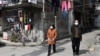 Algunos ciudadanos, pertrechados con mascarillas sanitarias, se aventuraban a deambular por las desérticas calles de Wuhan el 4 de marzo de 2020.