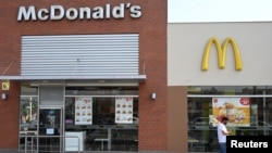 Una persona camina delante de un restaurante de la cadena McDonald's en Lima, Perú, uno de 29 locales de la empresa cerrados luego de la muerte de dos empleados. Diciembre 18 de 2019. Foto Reuters/Guadalupe Pardo.