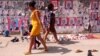 Dos mujeres mozambicanas pasan frente a una valla que publicita las elecciones legislativas en Maputo, la capital, el 11 de octubre de 2019. 