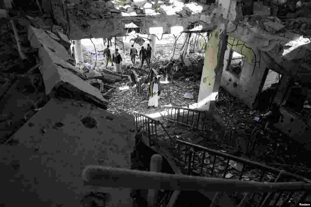 Security guards and journalists inspect the site of Saudi-led airstrike on a telecommunication station in Sana&#39;a, Yemen.