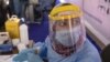 Un agent de santé se prépare à faire passer un test de dépistage du coronavirus à des automobilistes à l'Université Ain Shams au Caire, en Égypte, le 17 juin 2020.