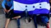 Des adolescents honduriens tenant le drapeau de leur pays en attendant de partir avec une caravane de migrants pour les États-Unis, San Pedro Sula, 14 janvier 2020. (Reuters)