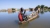 Un homme navigue sur une pirogue entre les maisons du quartier Tougoude, au sud-est du 9ème arrondissement de Ndjamena, inondé par le fleuve Logone, au Tchad le 8 octobre 2024. 